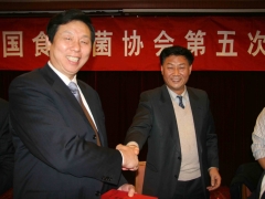 新当选的中国食用菌协会第五届理事会会长张祥茂祝贺新当选副会长的连云港国鑫食用菌成套设备有限公司董事长徐寿海并颁发证书   摄影：徐泽群